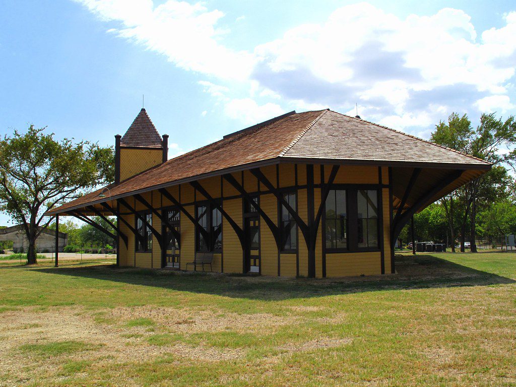 Rear view of the historic Hearne Depot Museum in Hearne, TX, with its yellow exterior and unique architectural design.