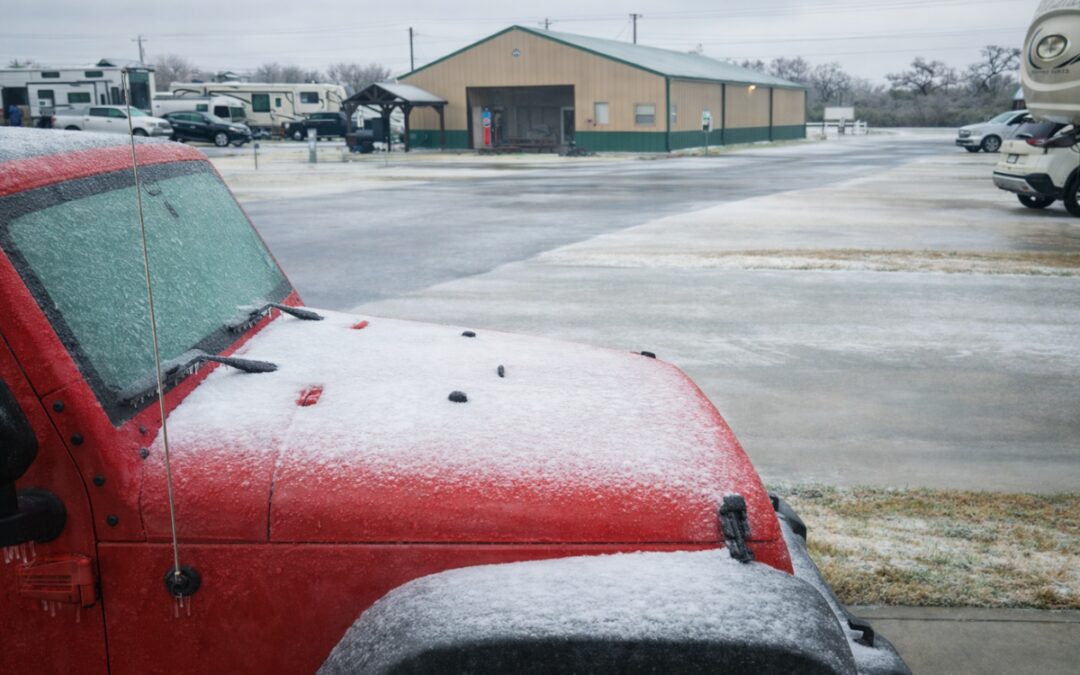 Ice covering a vehicle and RV park grounds during a winter storm in Bryan, Texas