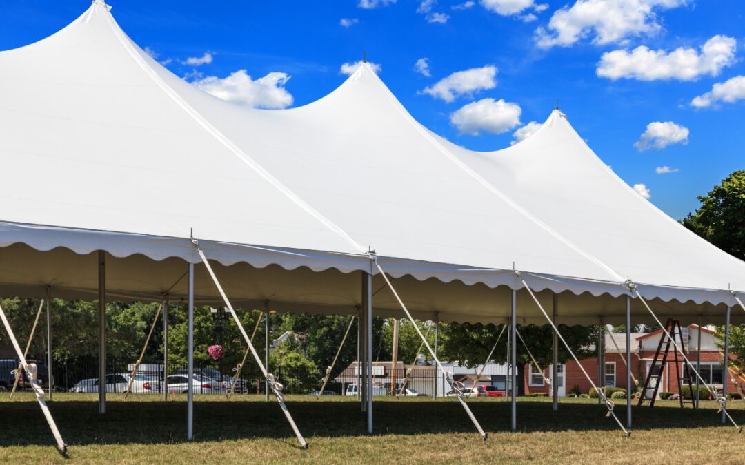 Large white event tent set up outdoors under a bright blue sky for a spring festival in Bryan-College Station Texas