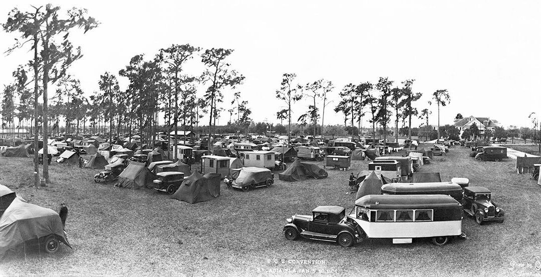 Panoramic black and white photo of the Tin Can Tourists convention in Arcadia Florida showing hundreds of early cars campers and trailers gathered in an open field circa 1920s